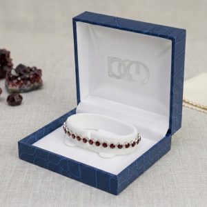 Make a sophisticated statement with this beautiful natural garnet tennis bracelet. Designed with a continuous row of natural garnet gemstones, this bracelet showcases the deep red tones that make garnet such a distinctive and sought-after gemstone. The stones are set in silver with a platinum-plated finish, giving the bracelet a refined and polished appearance. The classic tennis bracelet design makes this garnet bracelet versatile enough to wear every day while also adding elegance to evening and special-occasion looks. Whether you are searching for a natural garnet bracelet, a red gemstone tennis bracelet or a unique gemstone gift, this piece is a beautiful addition to any jewellery collection. Discover natural gemstone jewellery at Gecko Jewellers, including garnet jewellery, gemstone bracelets and unique jewellery in South Africa. Product Details Natural garnet gemstones Tennis bracelet design Silver setting Platinum-plated finish Rich red gemstone colour Suitable for everyday wear and special occasions Ideal as a gemstone gift Please note: Natural gemstones can vary slightly in colour, clarity and appearance. Each stone has its own natural characteristics, making every piece unique. Pieces may vary slightly from the pictures and videos shared.