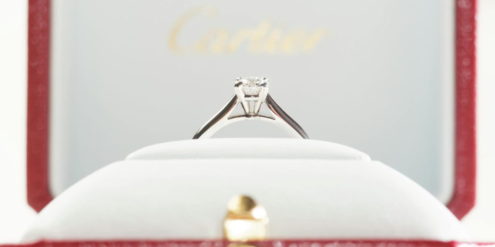 Elegant diamond engagement ring in a luxurious red box.
